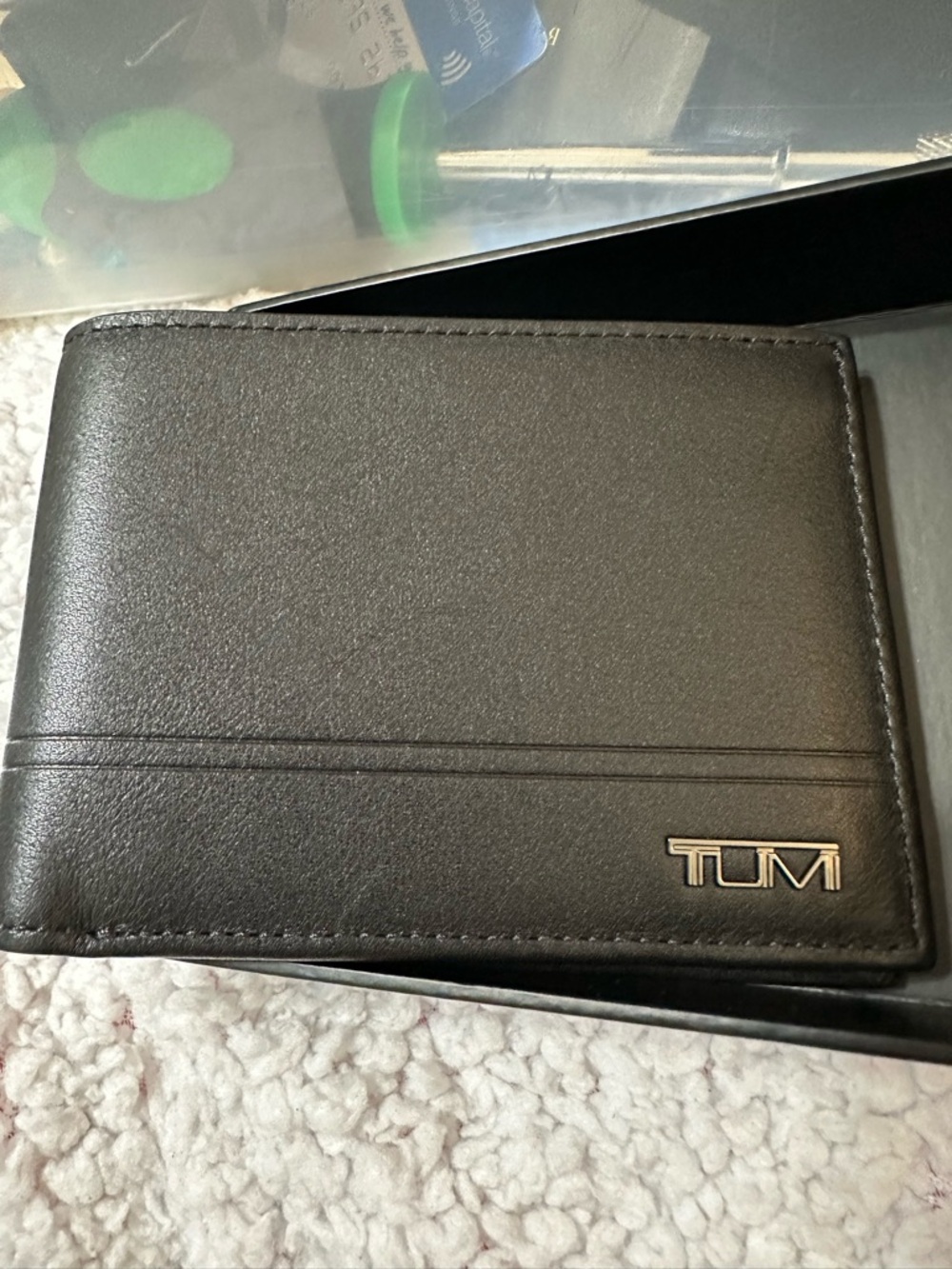 TUMI black leather cardholder with a titanium logo
